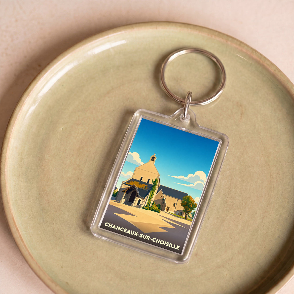 Porte-clés souvenir de la ville de Chanceaux-sur-Choisille avec une illustration stylisée de son église.