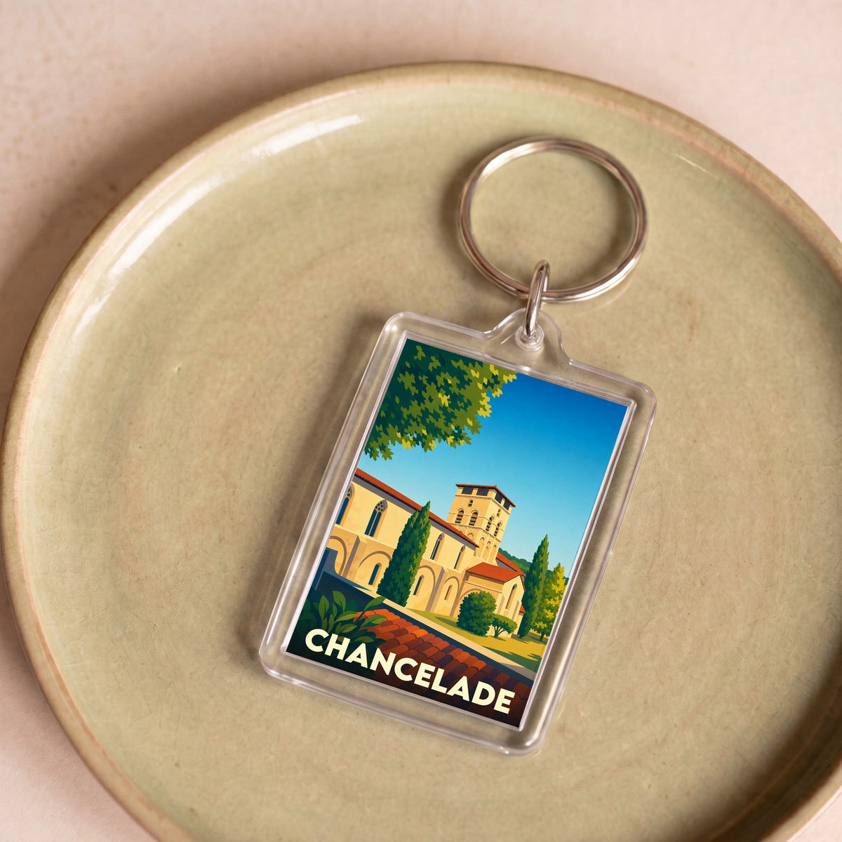 Porte-clés souvenir de la ville de Chancelade avec une illustration stylisée de son abbaye.