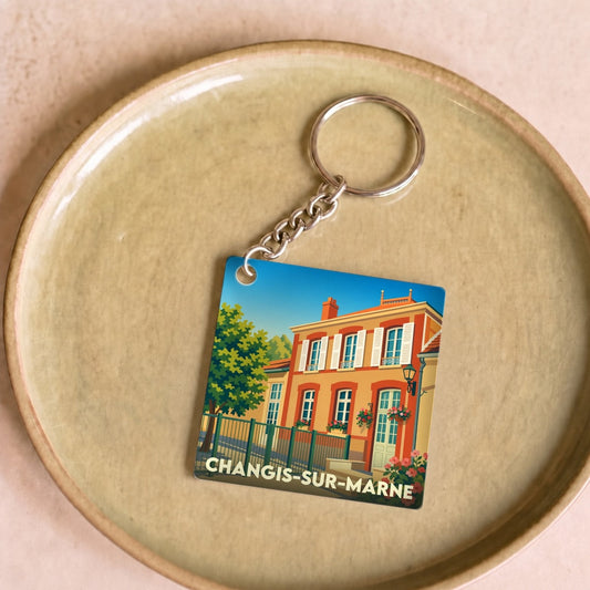 Porte-clés souvenir de la ville de Changis-sur-Marne avec une illustration colorée et stylisée d'une maison.