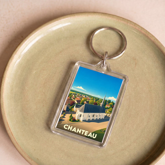 Porte-clés souvenir de la ville de Chanteau avec une illustration stylisée d'une église de campagne.