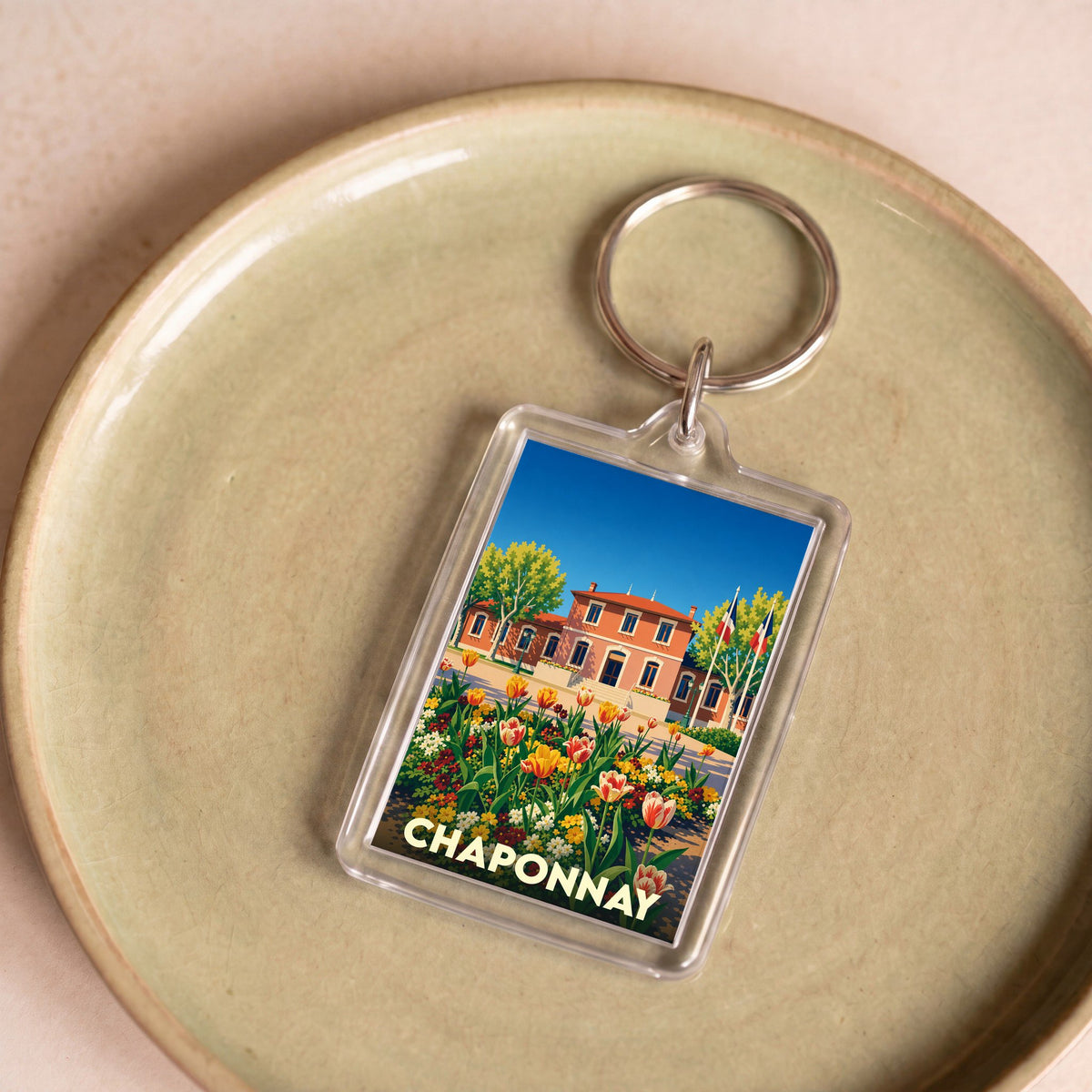 Porte-clés souvenir de la ville de Chaponnay avec une illustration stylisée et colorée.