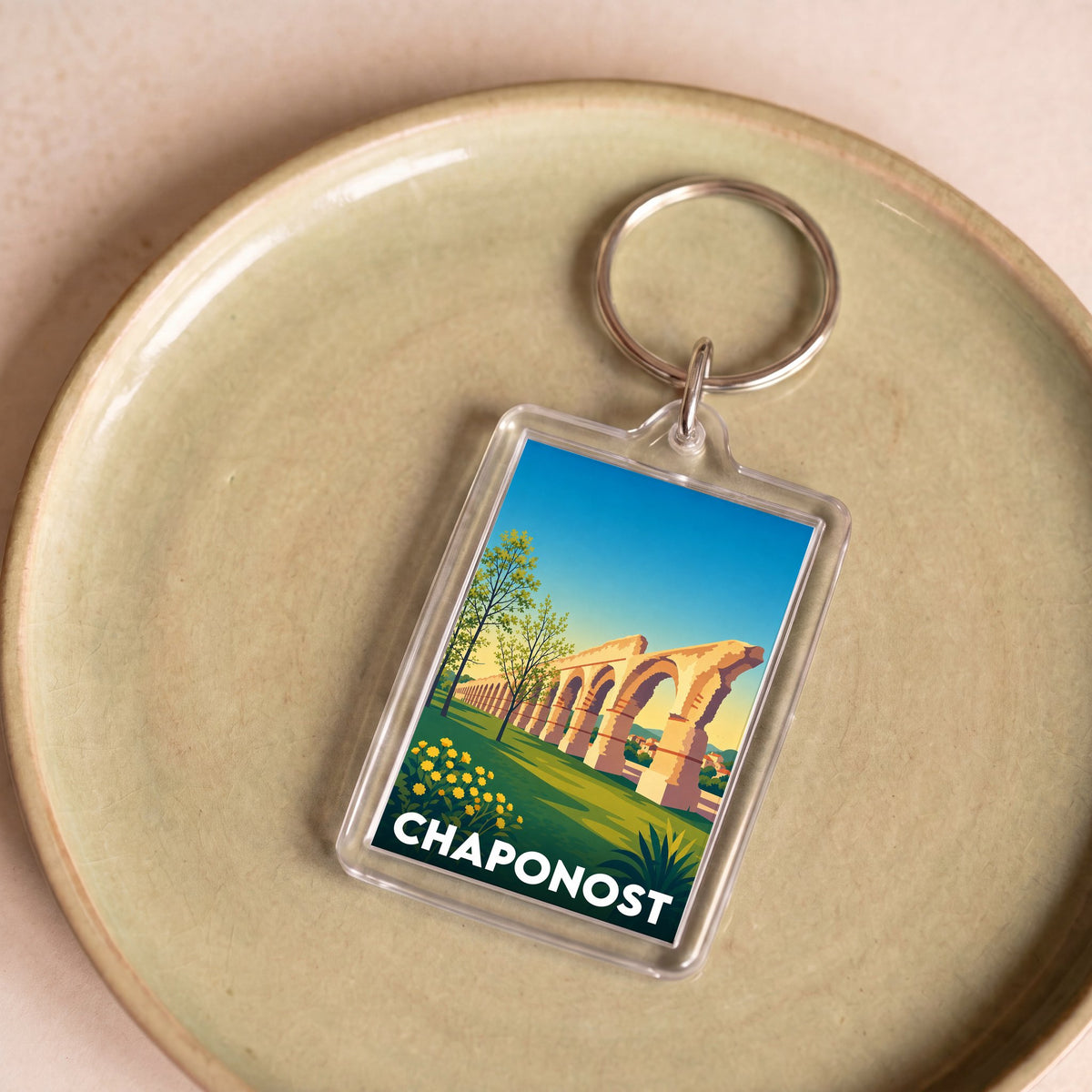 Porte-clés souvenir de la ville de Chaponost avec une illustration stylisée de son aqueduc romain.