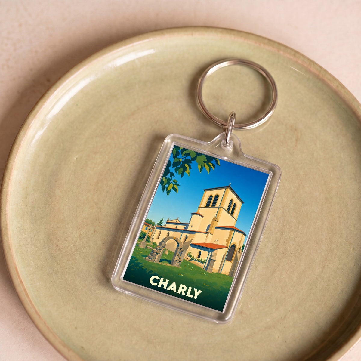 Porte-clés souvenir de la ville de Charly avec une illustration stylisée de son église.