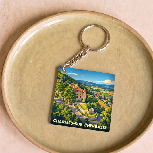 Porte-clés souvenir de la ville de Charmes-sur-l'Herbasse avec une illustration stylisée de son château et de ses paysages.