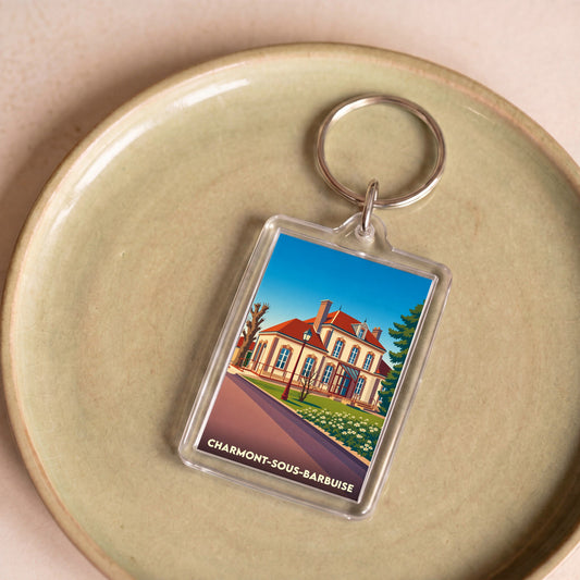 Porte-clés souvenir de la ville de Charmont-sous-Barbuise avec une illustration stylisée d'un bâtiment historique.