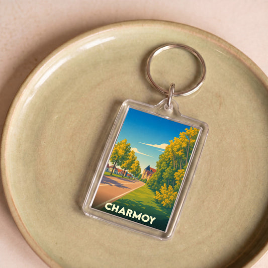 Porte-clés souvenir de la ville de Charmoy avec une illustration stylisée d'un paysage urbain verdoyant.