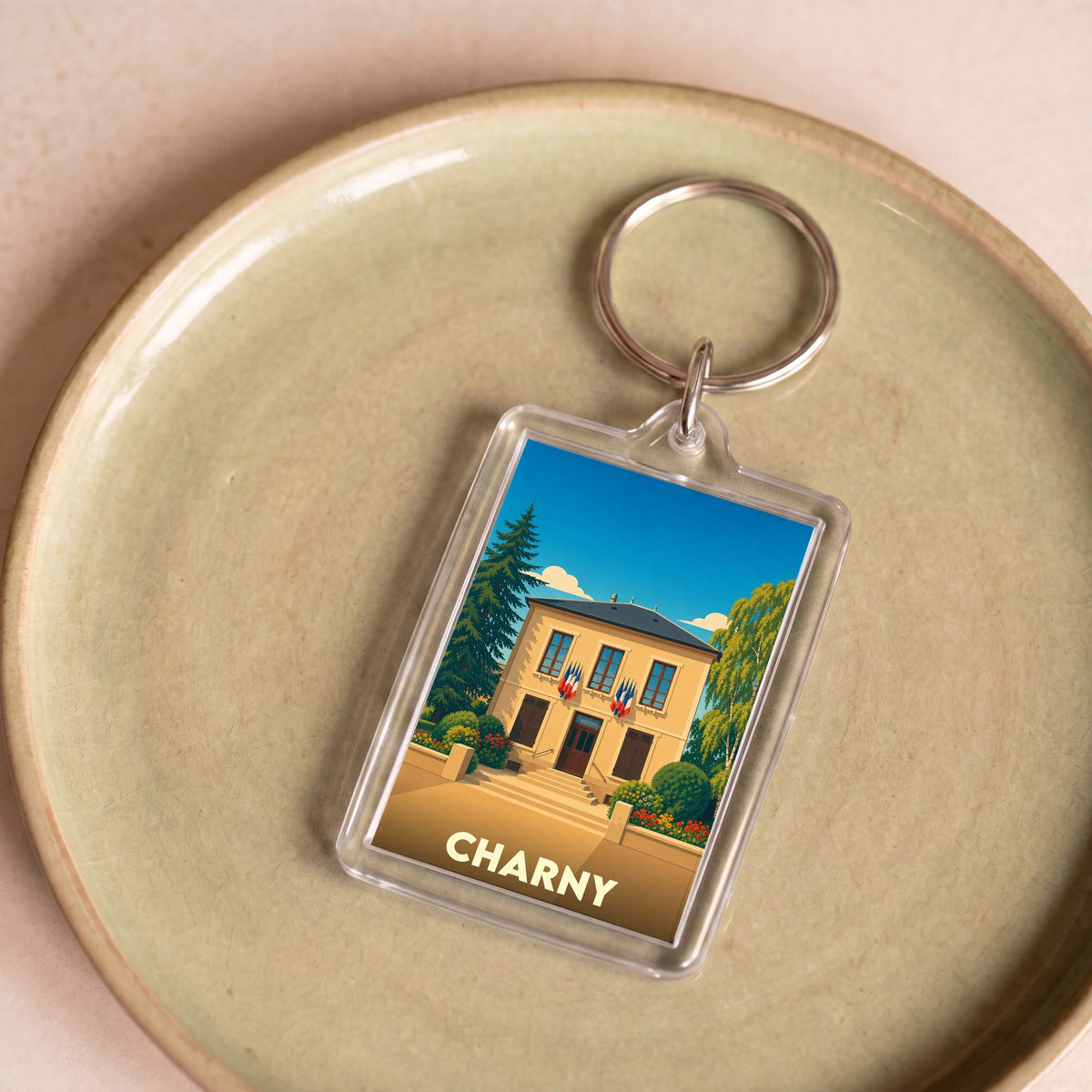 Porte-clés souvenir de la ville de Charny avec une illustration stylisée de sa mairie.