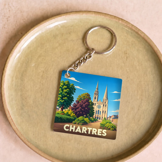 Porte-clés souvenir de la ville de Chartres avec une illustration stylisée de sa cathédrale.