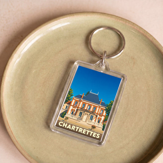 Porte-clés souvenir de la ville de Chartrettes avec une illustration stylisée de la mairie.