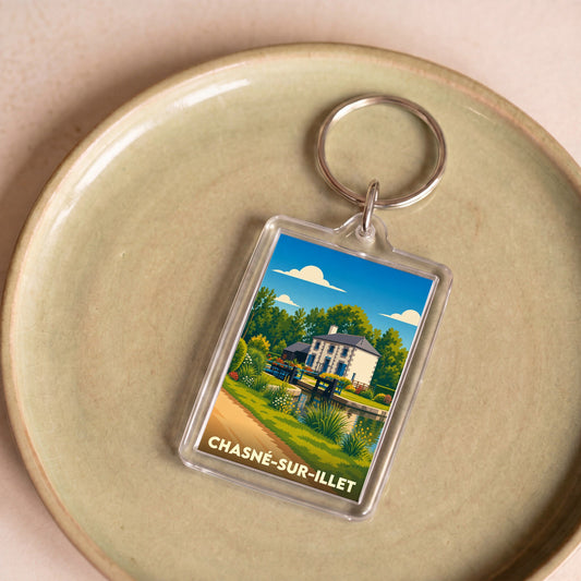 Porte-clés souvenir de la ville de Chasné-sur-Illet avec une illustration stylisée.