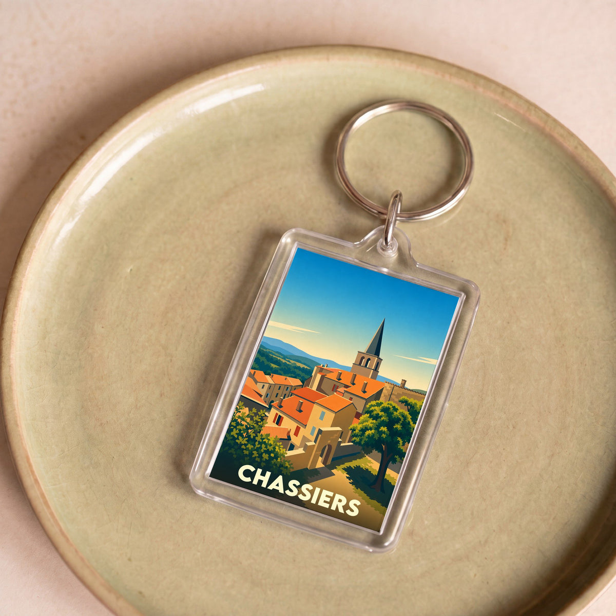 Porte-clés souvenir de la ville de Chassiers avec une illustration stylisée.