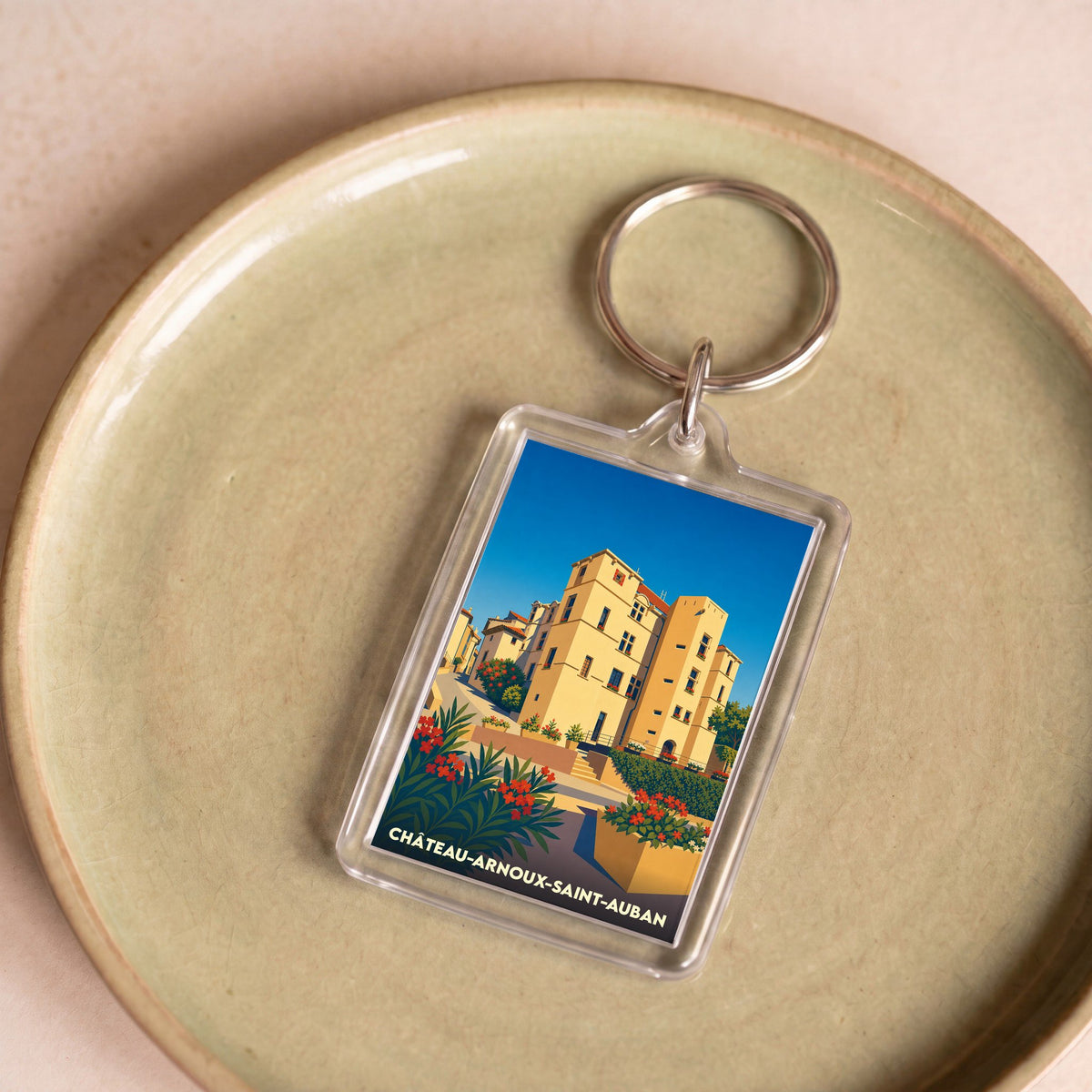 Porte-clés souvenir de la ville de Château-Arnoux-Saint-Auban avec une illustration stylisée.