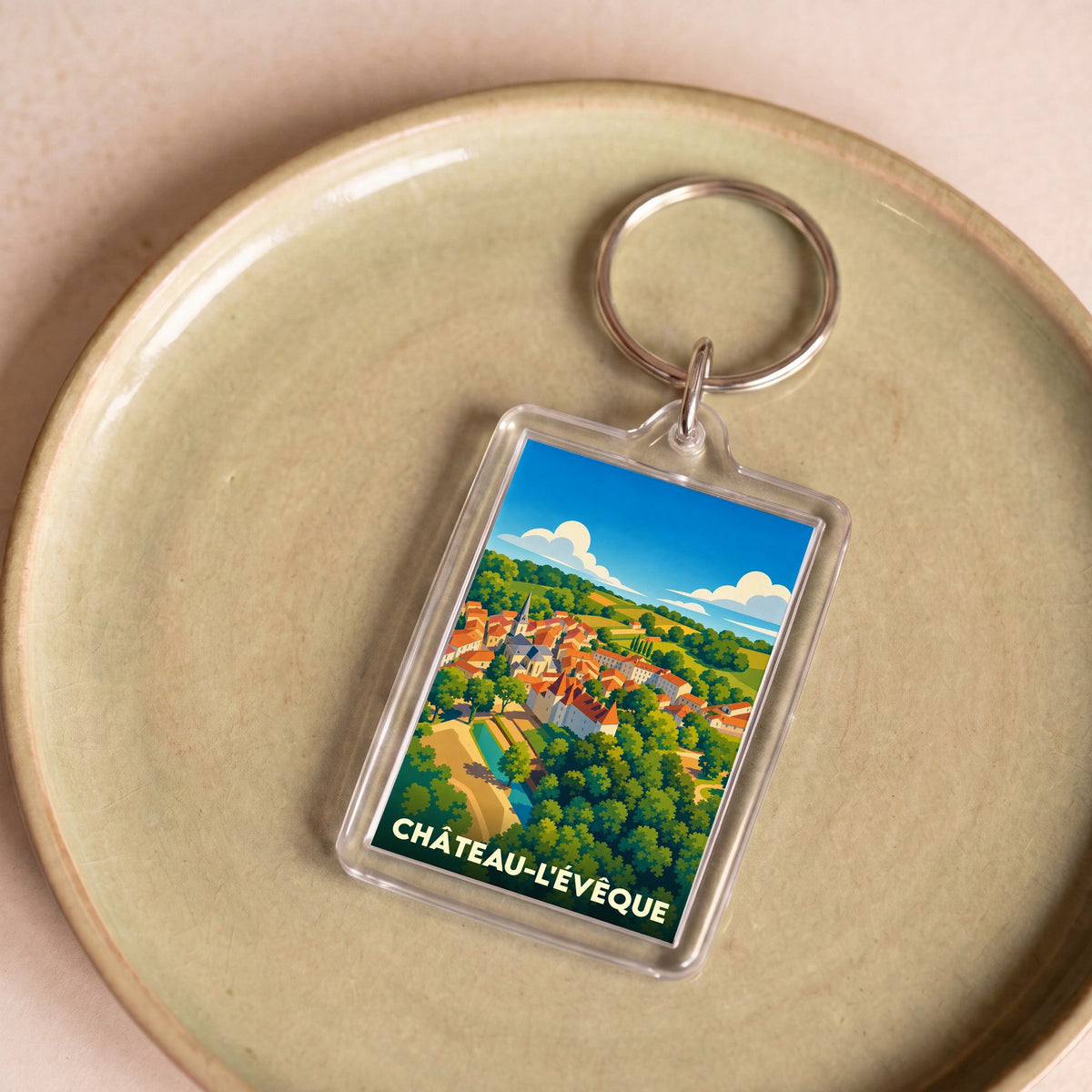 Porte-clés souvenir de la ville de Château-l'Évêque avec une illustration stylisée.