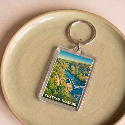 Porte-clés souvenir de la ville de Château-Thébaud avec une illustration stylisée d'un paysage de rivière.