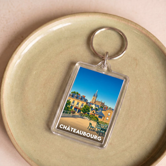 Porte-clés souvenir de la ville de Châteaubourg avec une illustration colorée et stylisée.