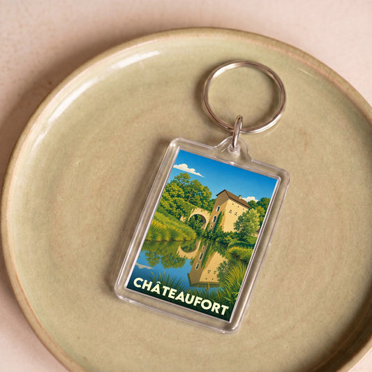 Porte-clés souvenir de la ville de Châteaufort avec une illustration stylisée d'un paysage champêtre.