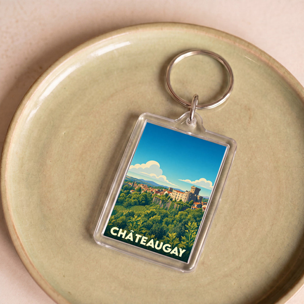 Porte-clés souvenir de la ville de Châteaugay avec une illustration stylisée.
