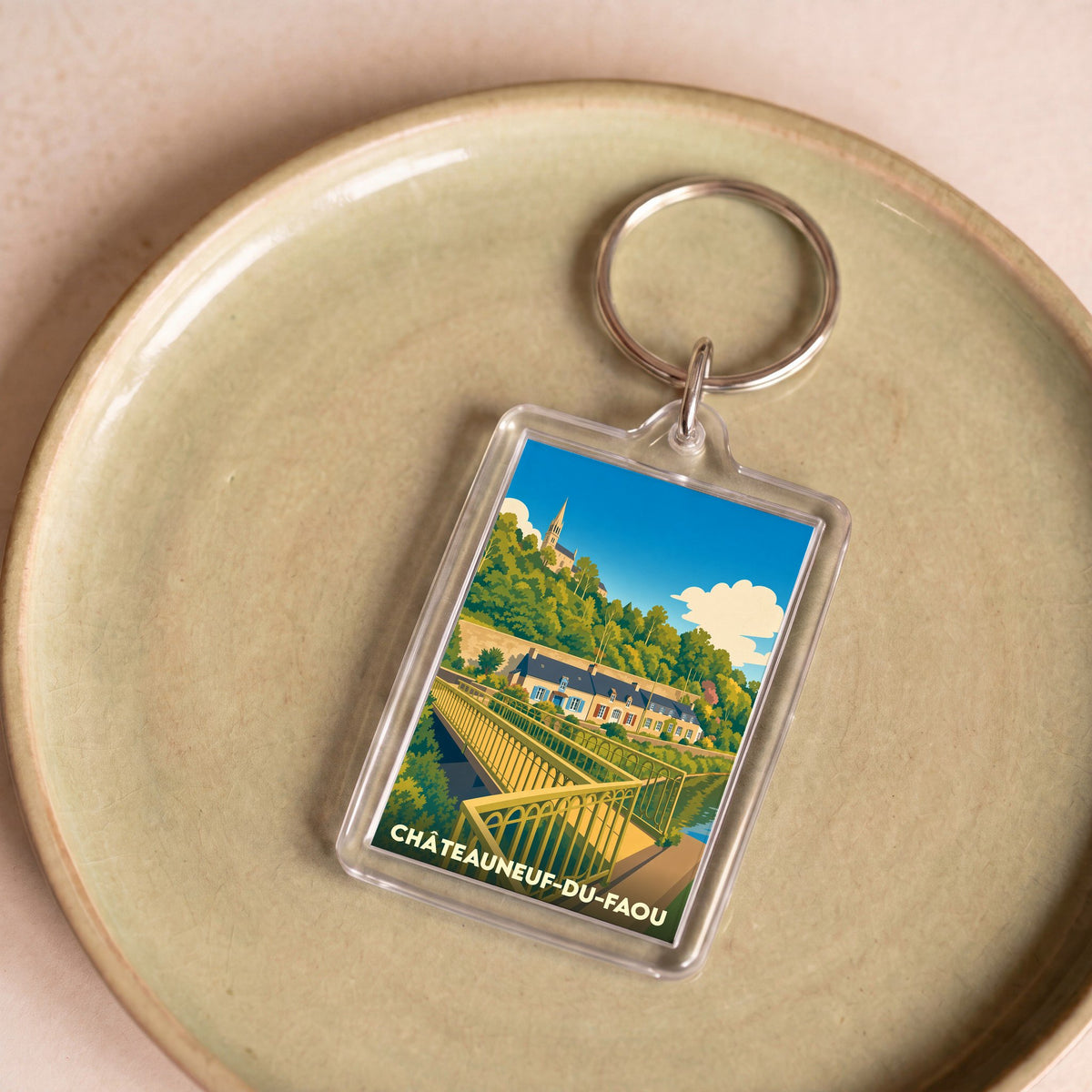 Porte-clés souvenir de la ville de Châteauneuf-du-Faou avec une illustration stylisée.