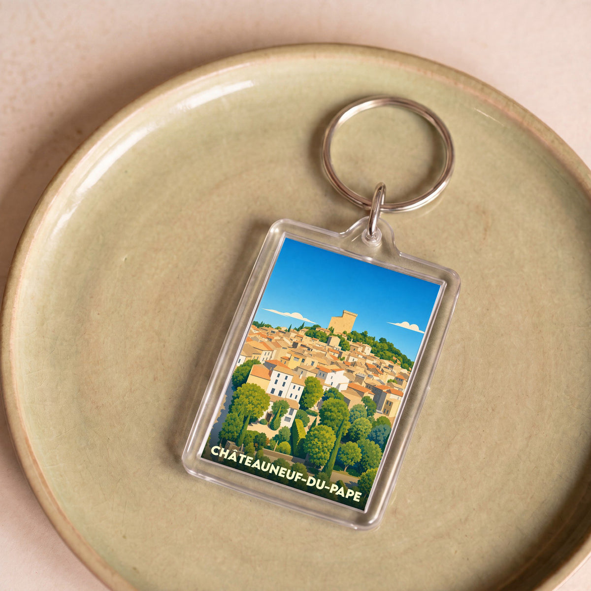 Porte-clés souvenir de Châteauneuf-du-Pape avec une illustration stylisée du village et de son château.