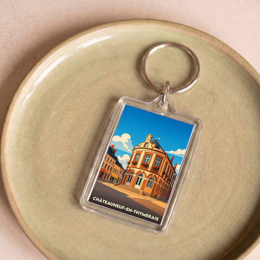 Porte-clés souvenir de la ville de Châteauneuf-en-Thymerais avec une illustration stylisée de son architecture.