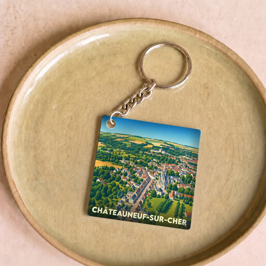 Porte-clés souvenir de la ville de Châteauneuf-sur-Cher avec une illustration aérienne stylisée.