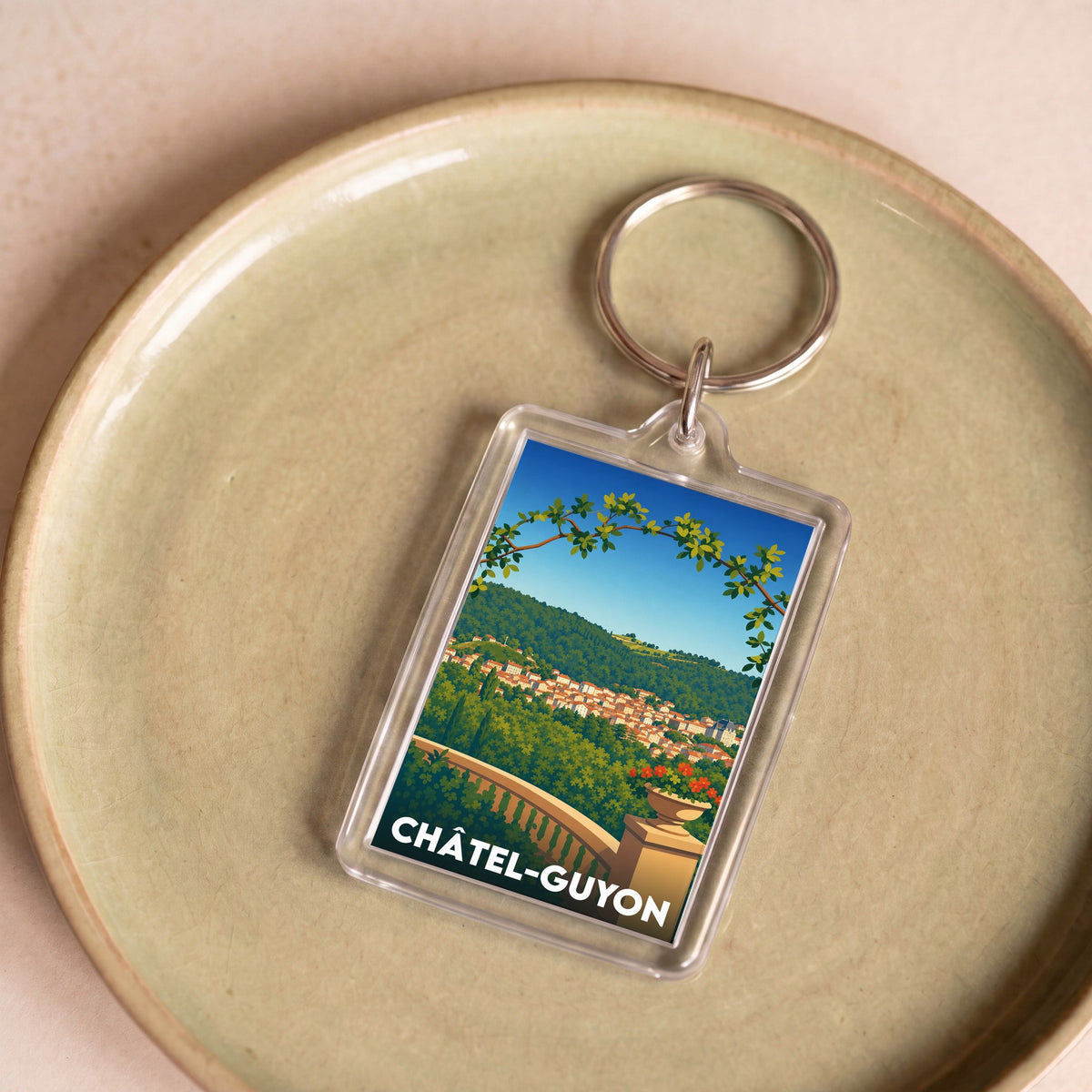 Porte-clés souvenir de la ville de Châtel-Guyon avec une illustration stylisée.