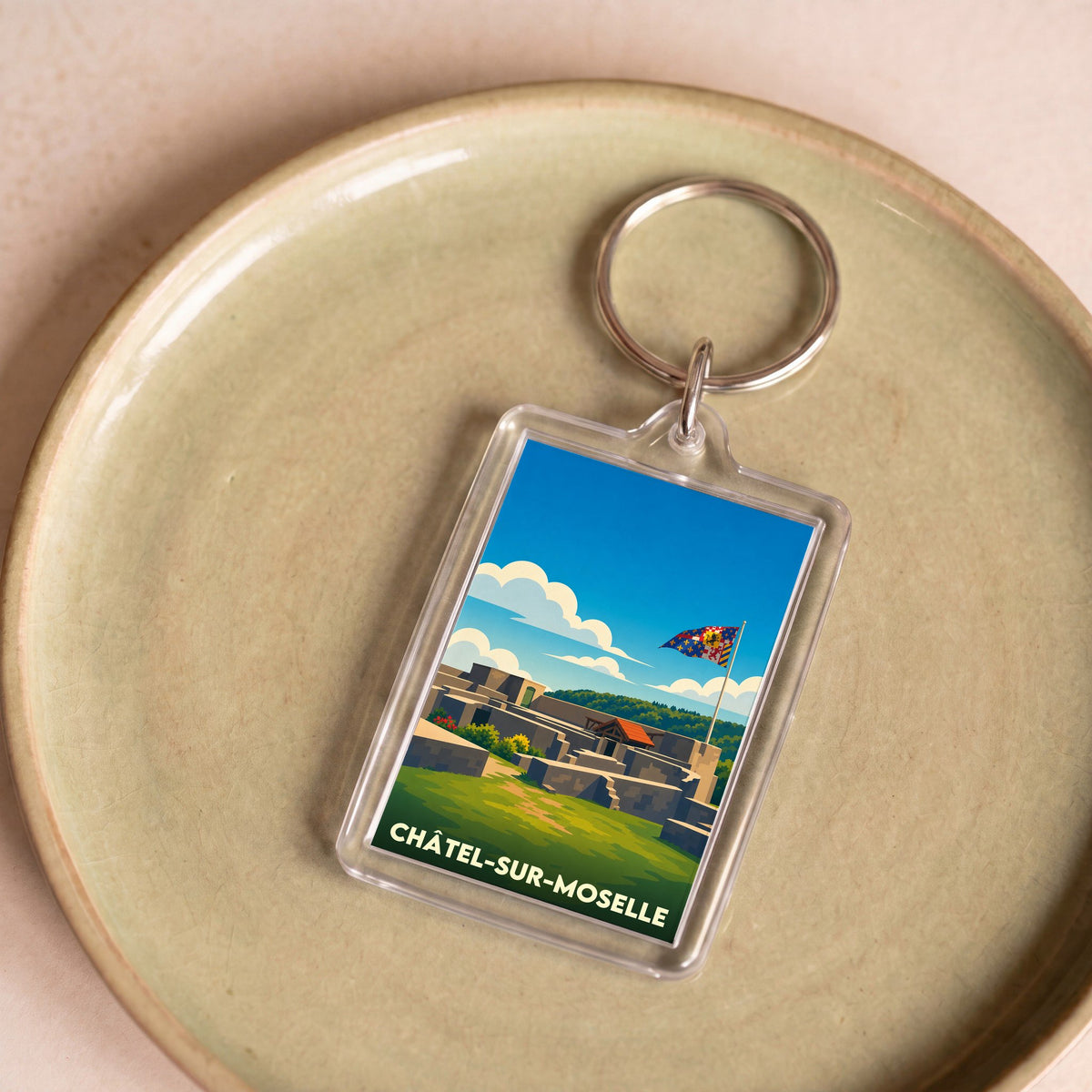 Porte-clés souvenir de Châtel-sur-Moselle avec une illustration stylisée de sa forteresse.