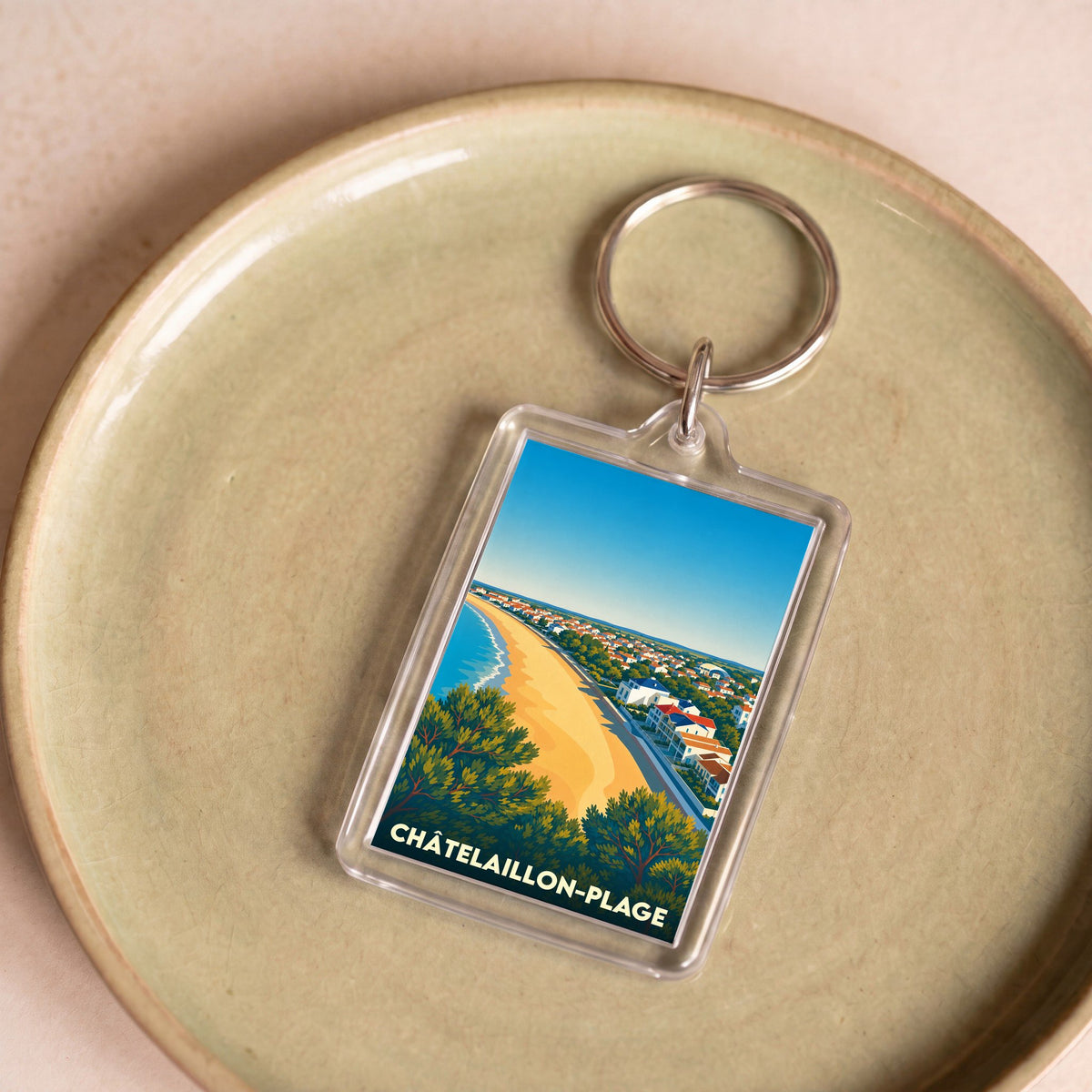 Porte-clés souvenir de Châtelaillon-Plage illustré d'une vue aérienne stylisée de la plage et de la ville.