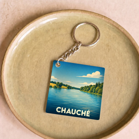Porte-clés souvenir de la ville de Chauché avec une illustration stylisée d'un paysage de lac.