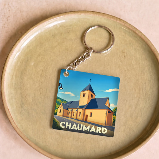 Porte-clés souvenir de la ville de Chaumard avec une illustration stylisée de son église.