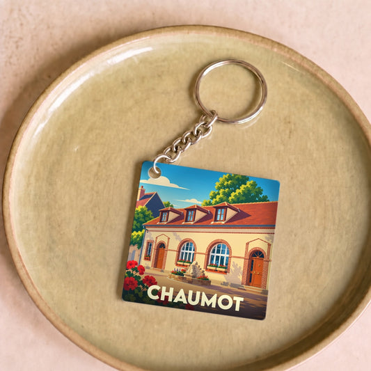 Porte-clés souvenir de la ville de Chaumot avec une illustration colorée et stylisée de son architecture.