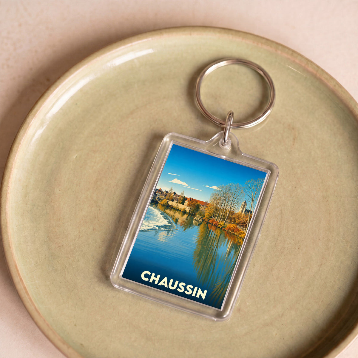Porte-clés souvenir de la ville de Chaussin avec une illustration stylisée.