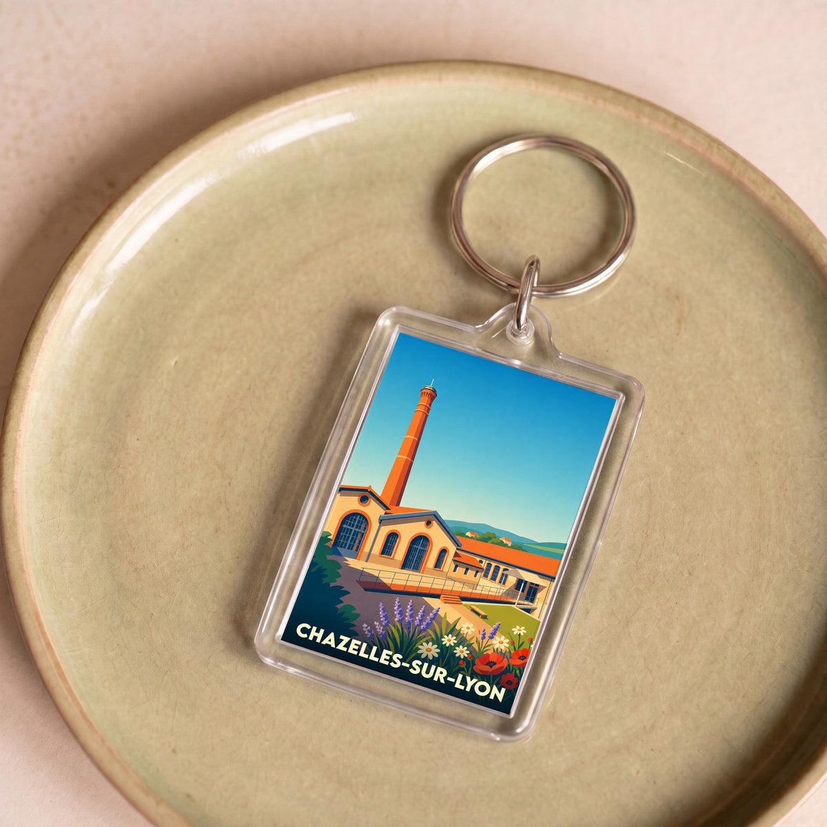 Porte-clés souvenir de la ville de Chazelles-sur-Lyon avec une illustration stylisée.