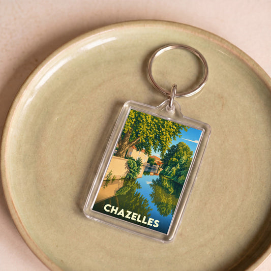 Porte-clés souvenir de la ville de Chazelles avec une illustration stylisée d'un canal arboré.