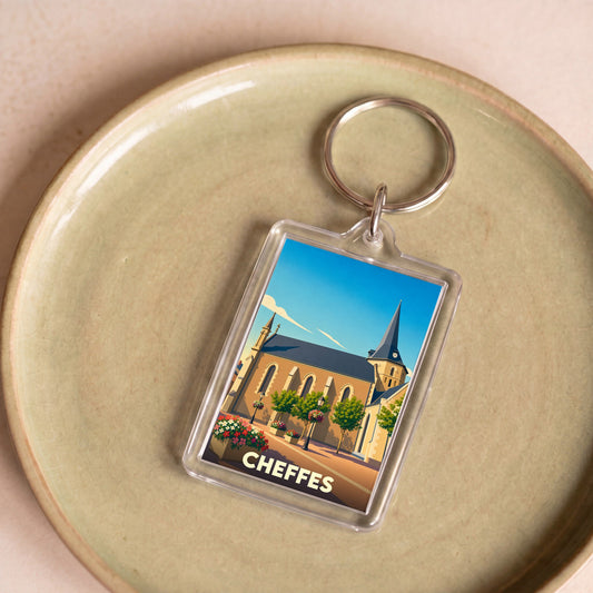 Porte-clés souvenir de la ville de Cheffes avec une illustration stylisée de son église.
