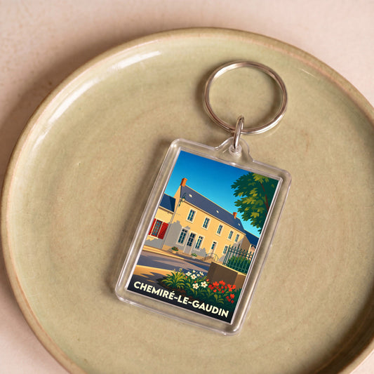 Porte-clés souvenir de la ville de Chemiré-le-Gaudin avec une illustration stylisée d'une maison ancienne.
