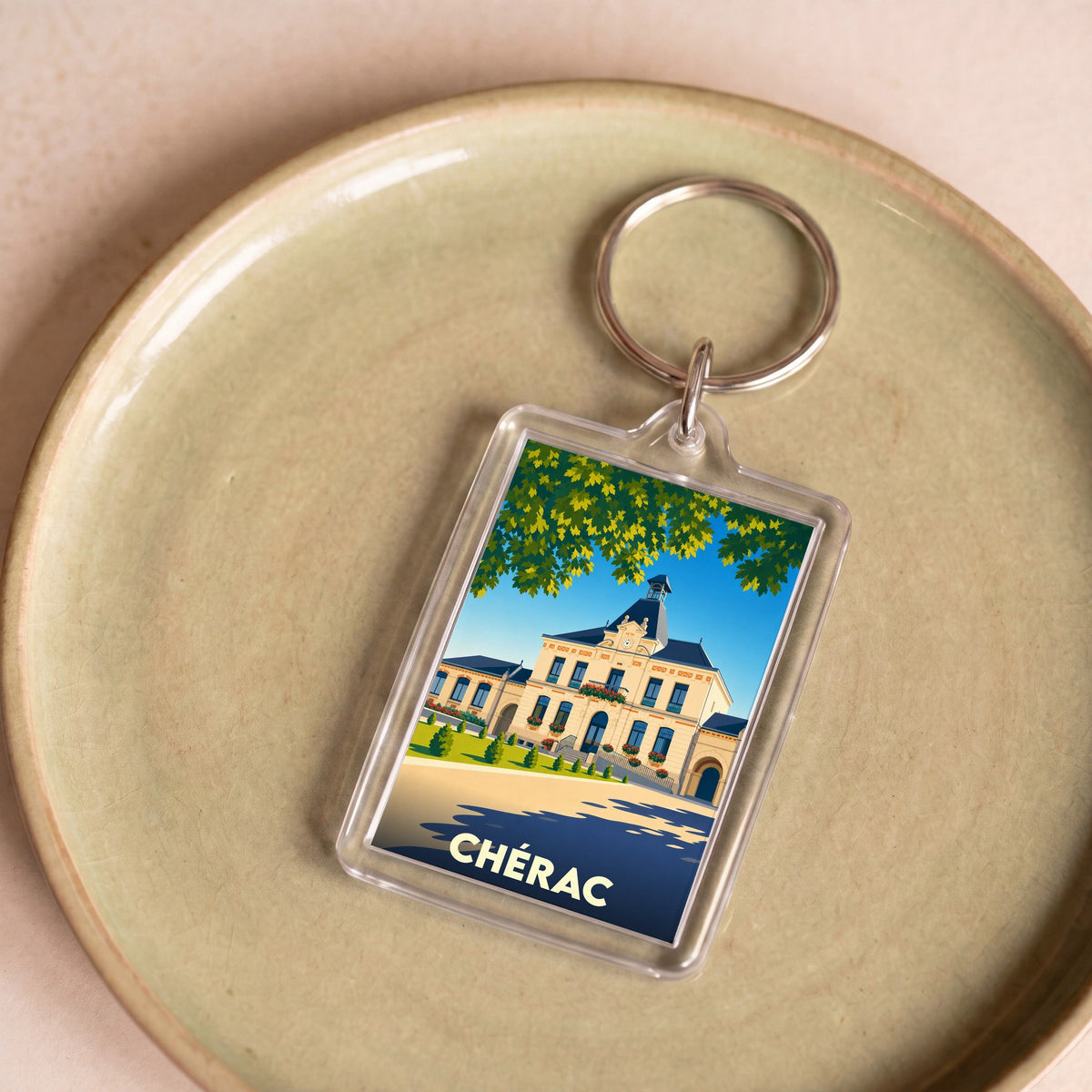 Porte-clés souvenir de la ville de Chérac avec une illustration stylisée de sa mairie.