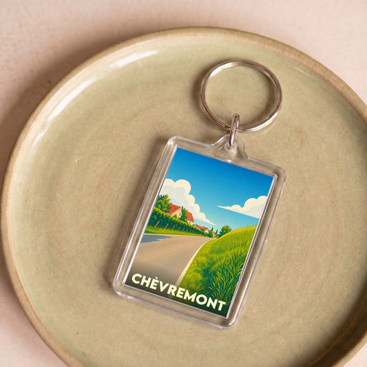 Porte-clés souvenir de la ville de Chèvremont avec une illustration stylisée de son paysage champêtre.