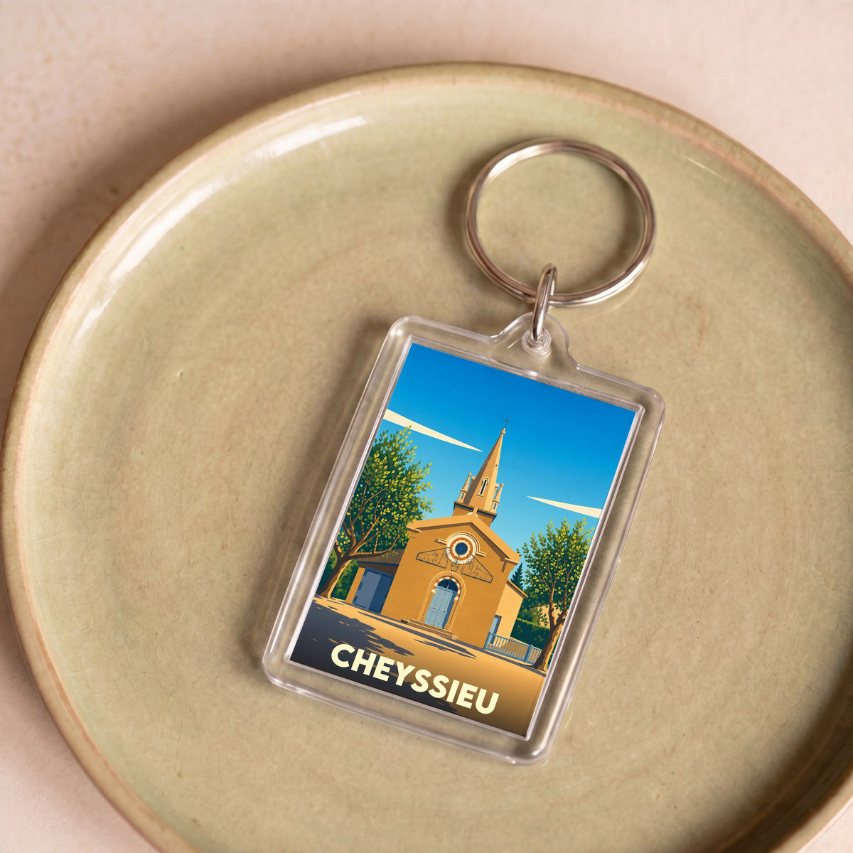 Porte-clés souvenir de la ville de Cheyssieu avec une illustration stylisée de son église.
