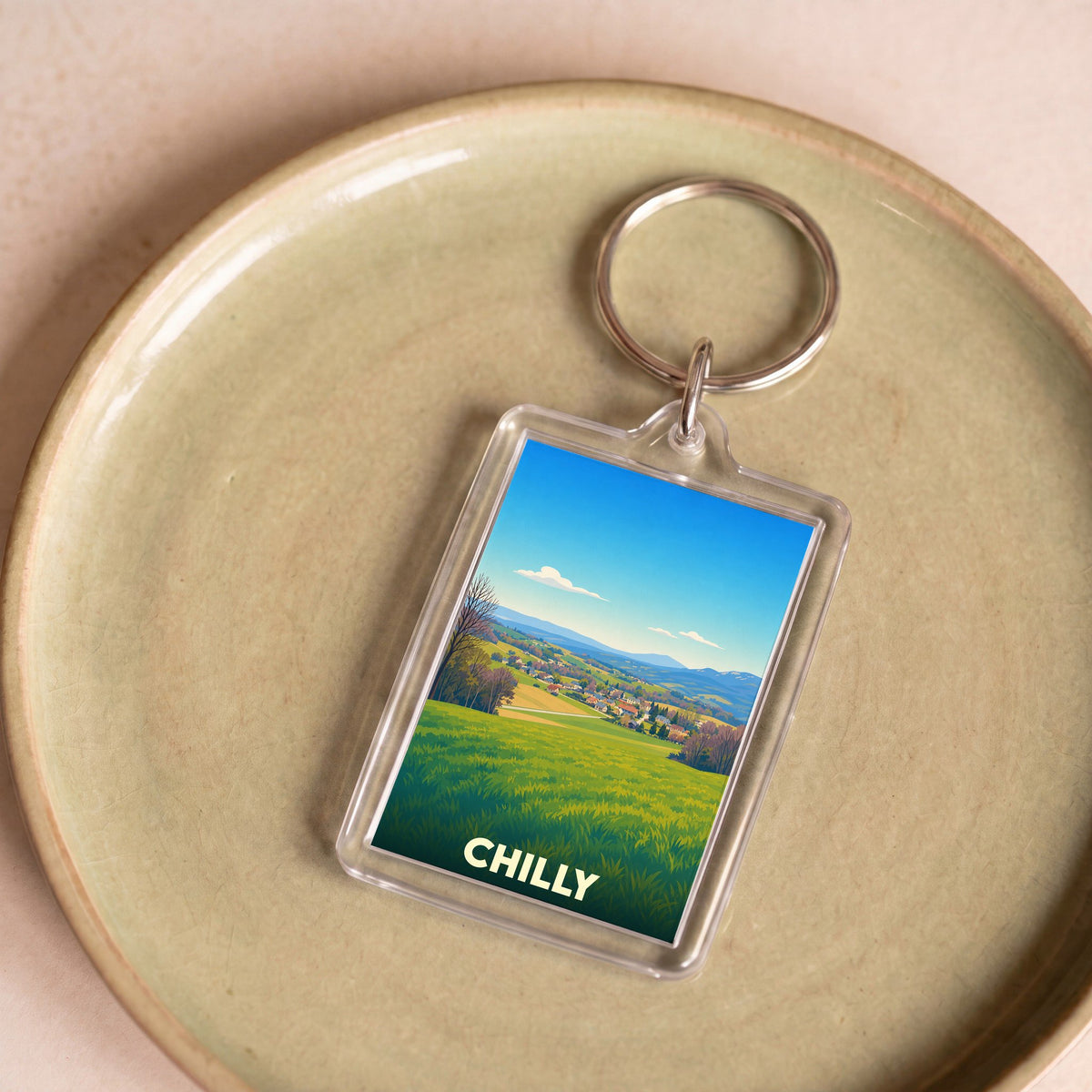 Porte-clés souvenir de la ville de Chilly avec une illustration paysagère stylisée.
