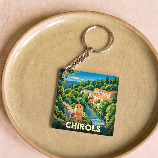 Porte-clés souvenir de la ville de Chirols avec une illustration stylisée d'un paysage montagneux et d'une rivière.