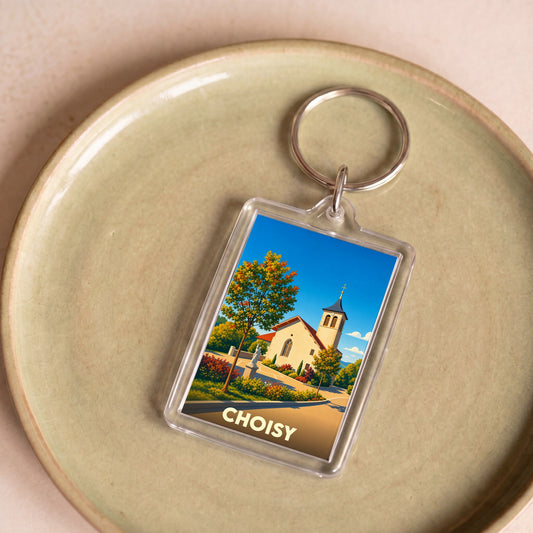 Porte-clés souvenir de la ville de Choisy avec une illustration stylisée de son église sous un ciel bleu.