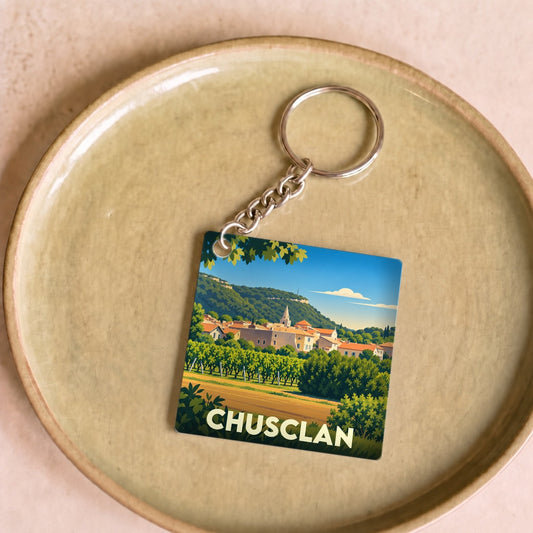 Porte-clés souvenir de la ville de Chusclan avec une illustration stylisée de son paysage provençal.