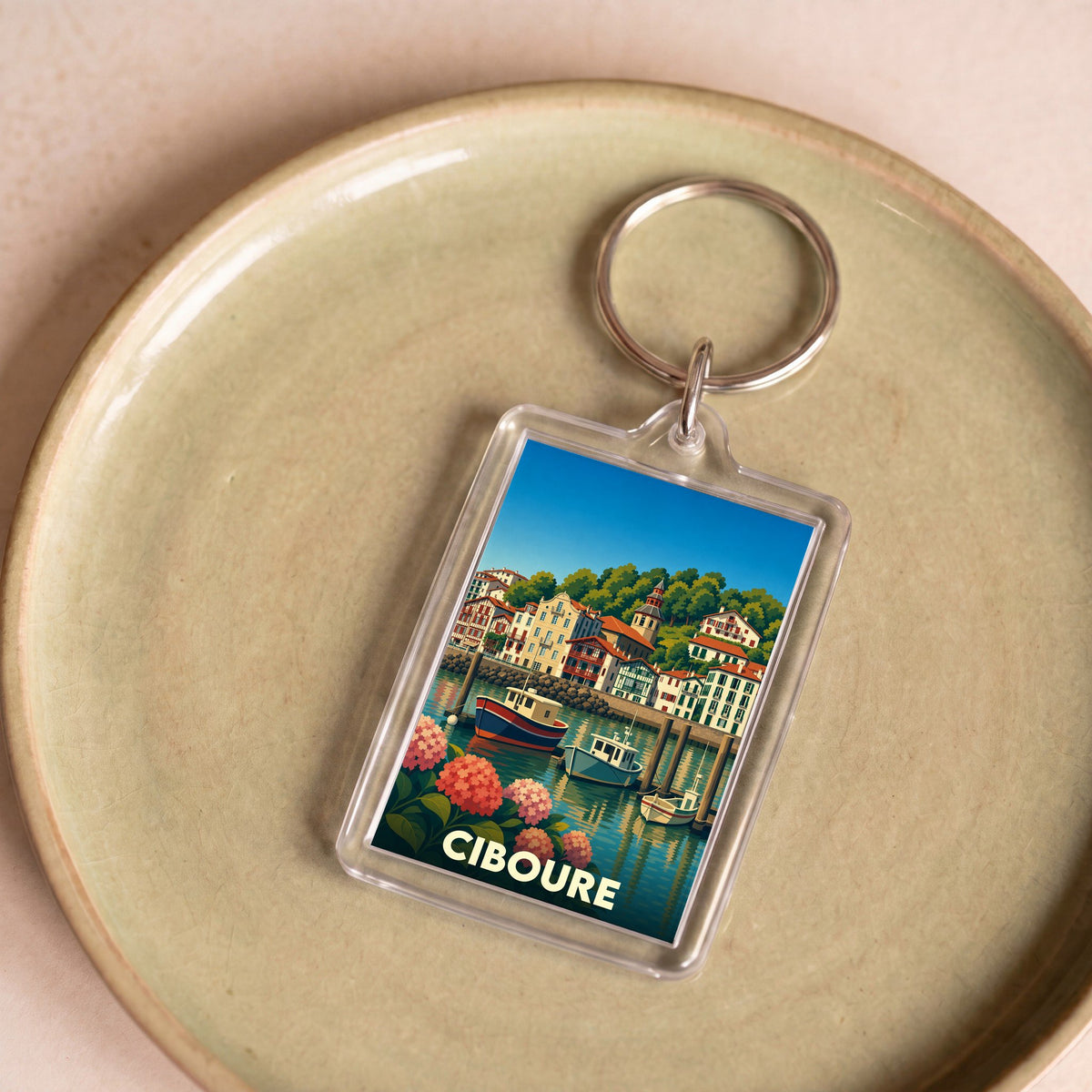Porte-clés souvenir de la ville de Ciboure avec une illustration stylisée de son port.