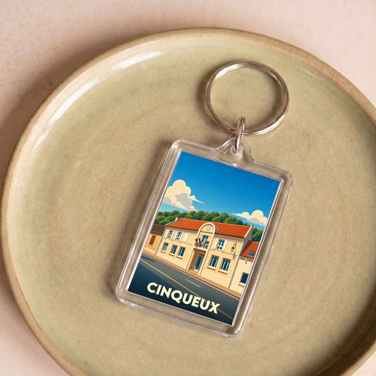 Porte-clés souvenir de la ville de Cinqueux avec une illustration stylisée de sa mairie.