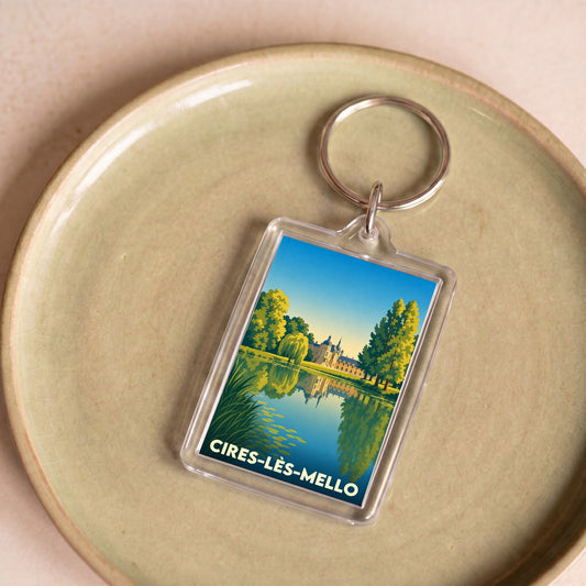 Porte-clés souvenir de la ville de Cires-lès-Mello avec une illustration stylisée d'un château se reflétant dans l'eau.