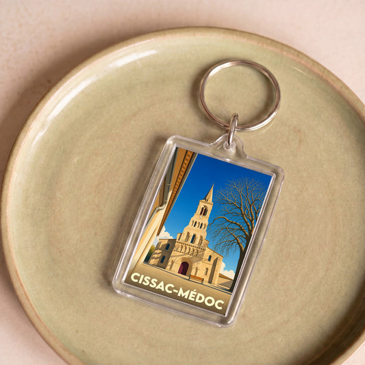 Porte-clés souvenir de la ville de Cissac-Médoc avec une illustration stylisée de son église.