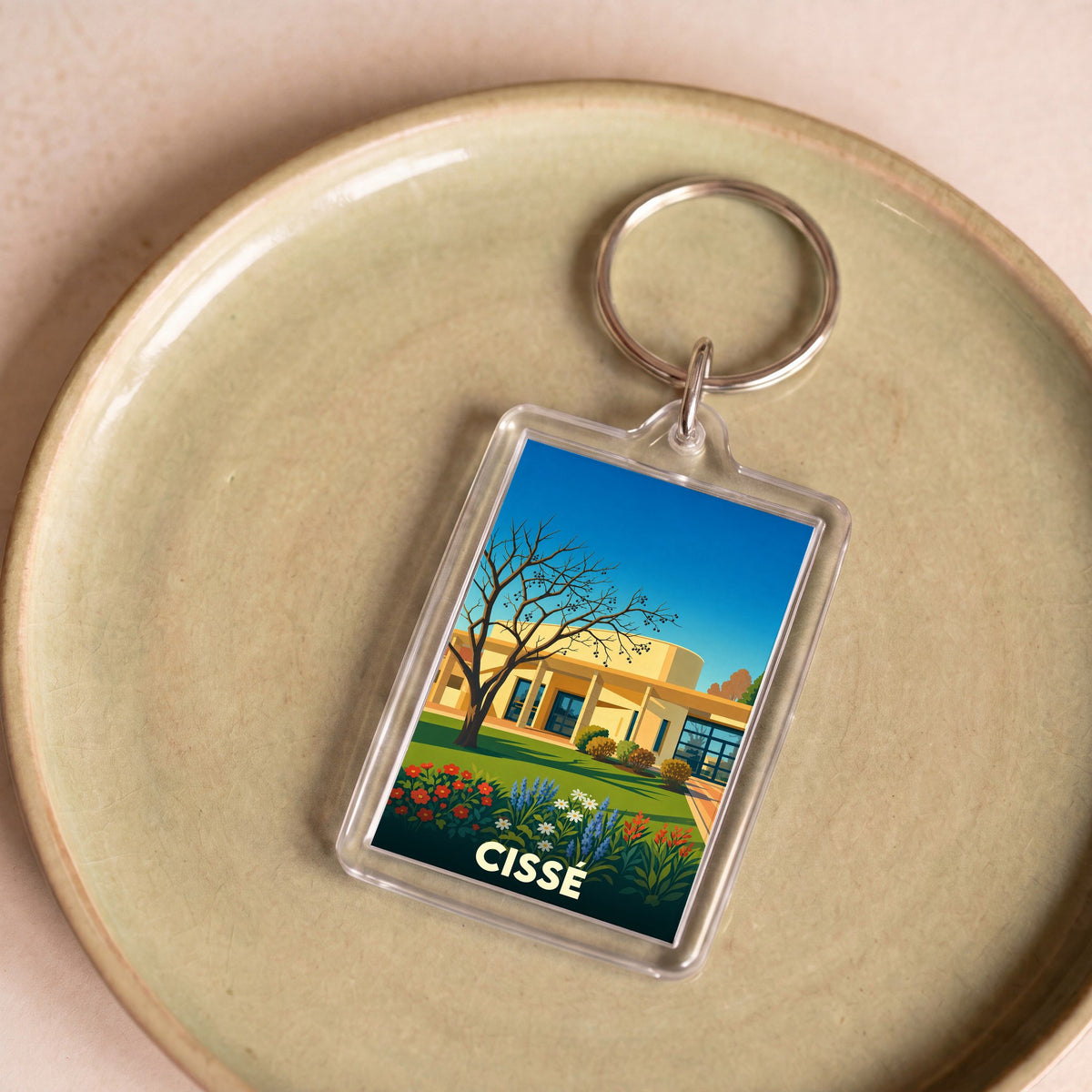 Porte-clés souvenir de la ville de Cissé avec une illustration stylisée de paysage urbain.