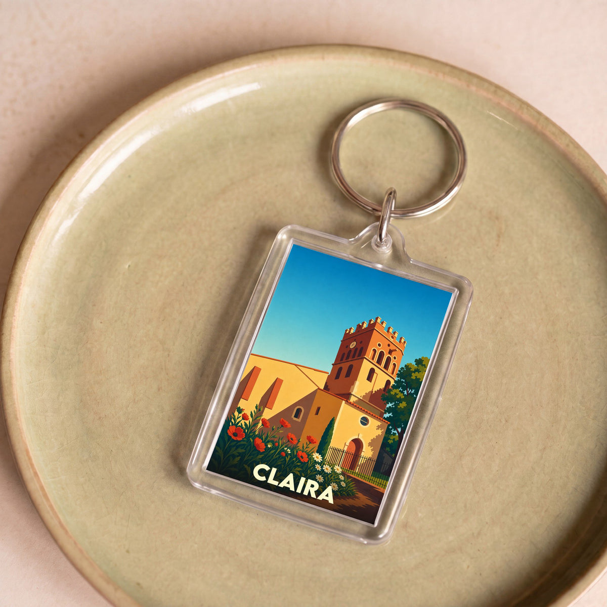 Porte-clés souvenir de la ville de Claira avec une illustration stylisée de son église.