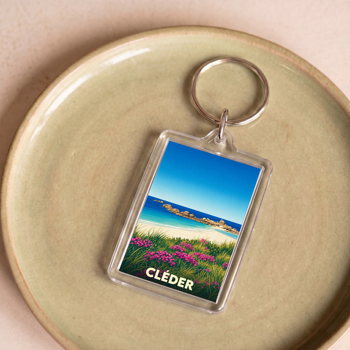 Porte-clés souvenir de la ville de Cléder avec une illustration stylisée de plage.
